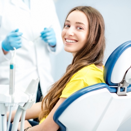 Woman in yellow blouse smiling in Mansfield dental office