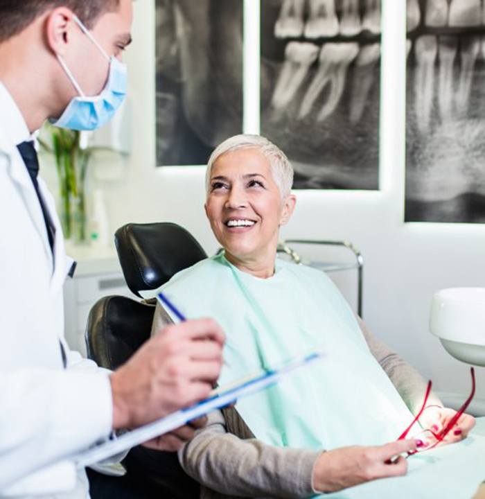 a patient smiling at her implant dentist