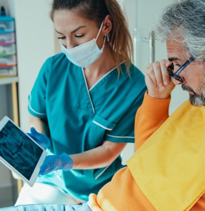 a dentist showing a patient a dental X-ray