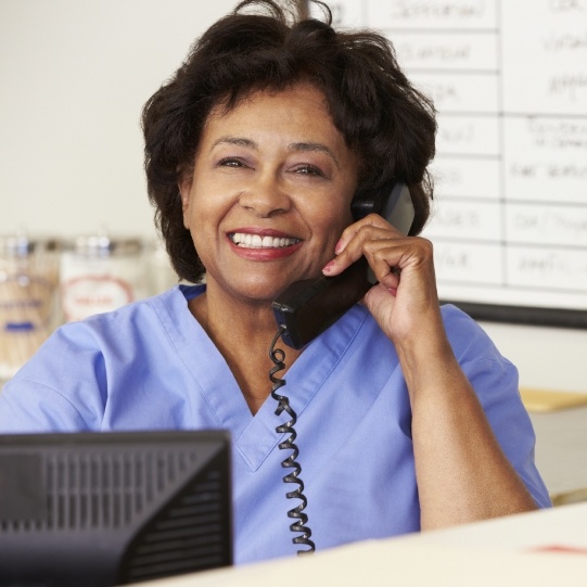 Smiling Mansfield dental team member talking on phone