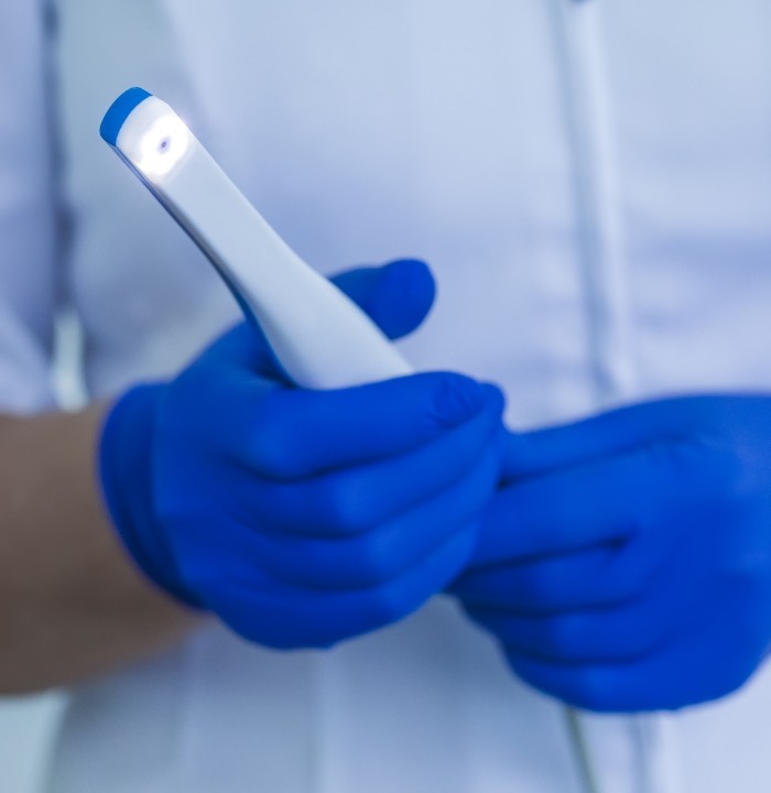 Gloved hands holding an intraoral camera