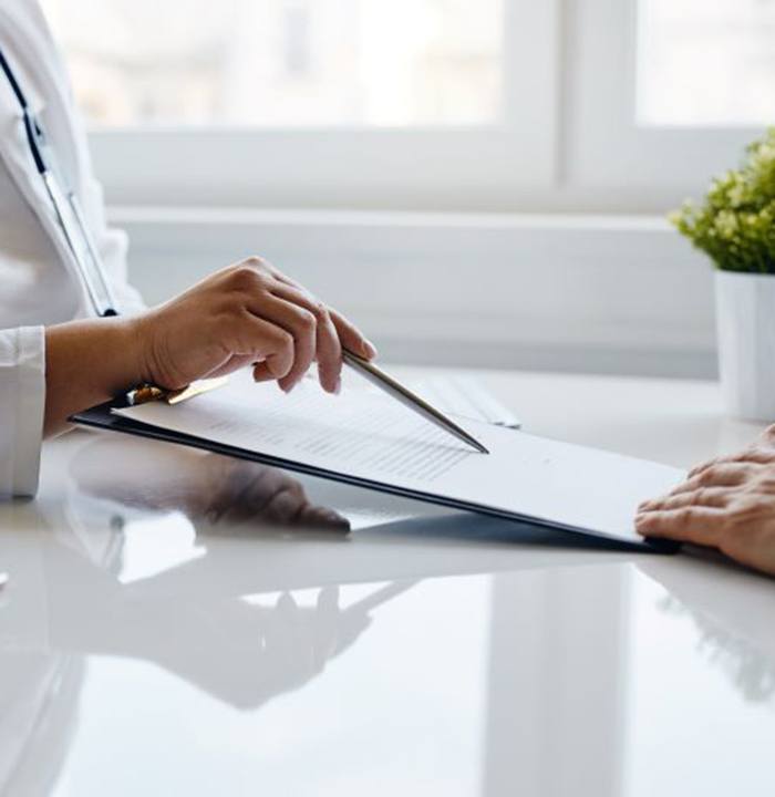 Patient and doctor sitting at desk, reviewing document