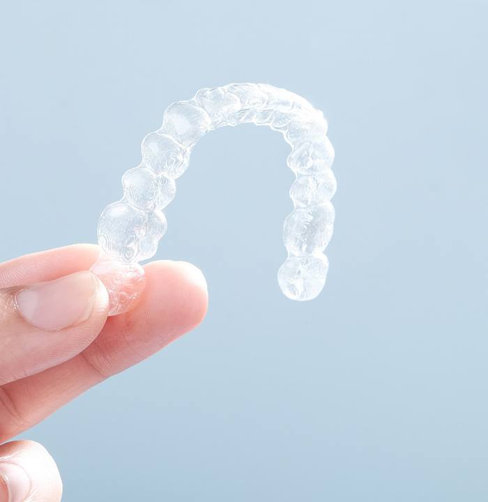 Patient holding up clear aligner