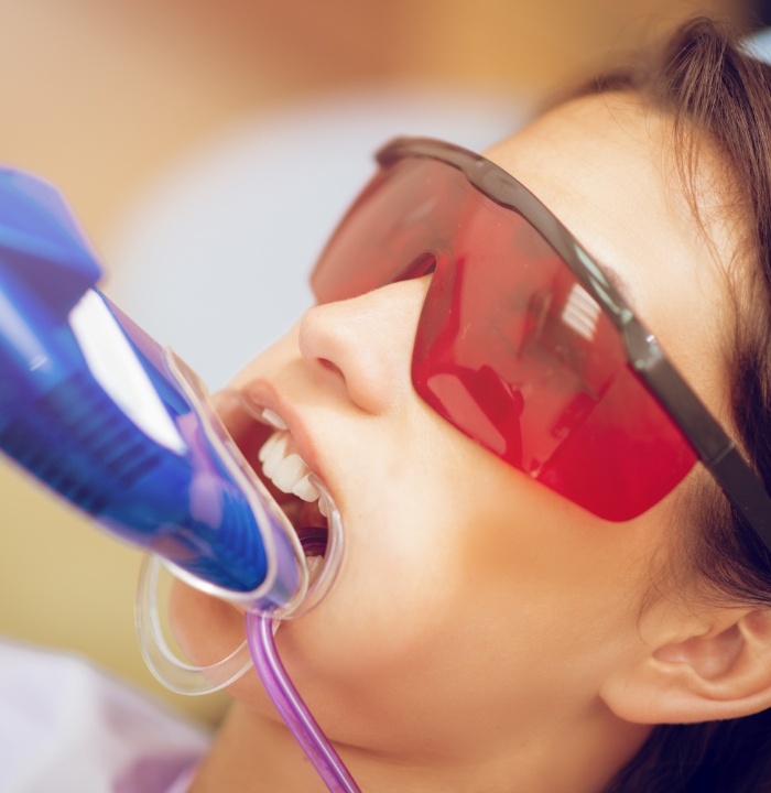 Young woman in dental chair with fluoride trays on her teeth