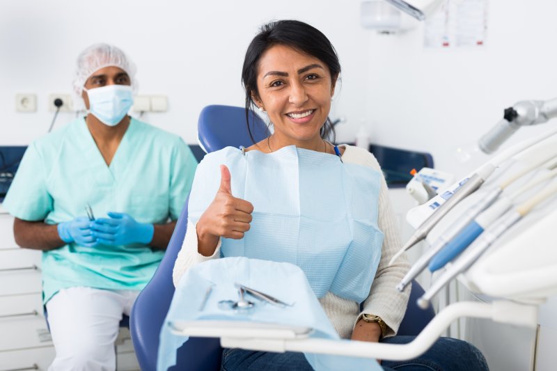 Patient giving a thumbs-up in front of their implant dentist